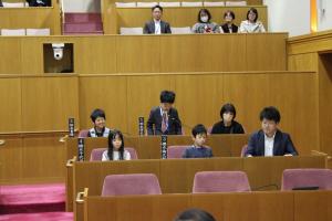 こども議会体験会でこども（1人目）が議員席で質問している様子の写真