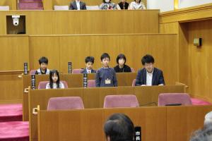 こども議会体験会でこども（3人目）が議員席で質問している様子の写真