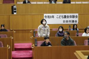 こども議会体験会でこども（7人目）が議員席で質問している様子の写真