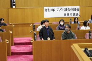 こども議会体験会でこども（8人目）が議員席で質問している様子の写真