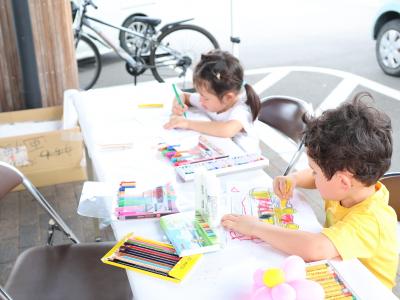 子ども2人がバスのぬり絵をしている様子の写真